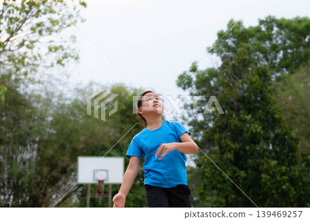 Asian student girl shooting a basketball on the school court, Back to school and healthy lifestyle concept. 139469257