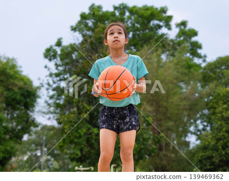 Asian student girl shooting a basketball on the school court, Back to school and healthy lifestyle concept. 139469362