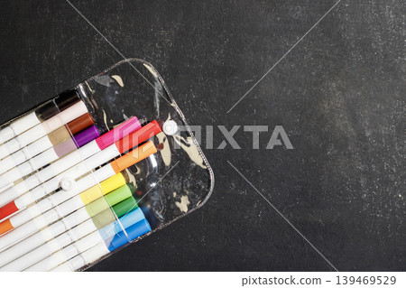 Colorful markers in a clear case on a blackboard. Art and Education Supplies. Creativity Concept. Colorful pens. High quality photo Colorful markers in a clear case on a blackboard. Art and Education Supplies. Creativity Concept. Colorful pens. High quality photo 139469529