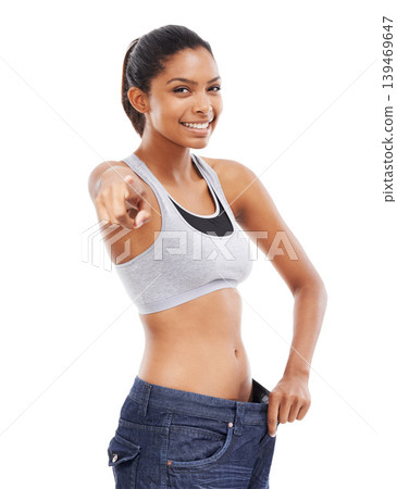 Happy woman, portrait and pants pointing in weight loss, choice or decision against a white studio background. Attractive young female person or model smile for pick or choose in health and wellness Happy woman, portrait and pants pointing in weight loss, choice or decision against a white studio background. Attractive young female person or model smile for pick or choose in health and wellness 139469647