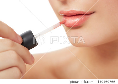 Woman, makeup and beauty with lipgloss, hand and closeup for skin, cosmetics on white background. Model, beautiful and headshot with shine, skincare or clean for facial glow, cosmetology or grooming Woman, makeup and beauty with lipgloss, hand and closeup for skin, cosmetics on white background. Model, beautiful and headshot with shine, skincare or clean for facial glow, cosmetology or grooming 139469766