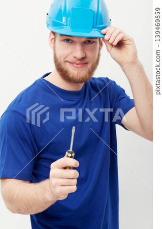 Construction worker man, screwdriver and studio portrait with smile, helmet and ready by white background. Person, handyman or contract with tools, safety and pride for job, services and maintenance Construction worker man, screwdriver and studio portrait with smile, helmet and ready by white background. Person, handyman or contract with tools, safety and pride for job, services and maintenance 139469859