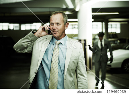 Man in parking, phone call and criminal following with gun, danger and walking in basement. Crime, kidnapping and person in garage talking on cellphone with cars, scary thief or gangster in shadow. 139469989