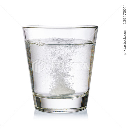 Effervescent tablet dissolving in water glass creating bubbles Effervescent tablet dissolving in water glass creating bubbles 139470044