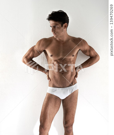 Man, underwear and wall background with body, healthy and thinking with vision, fitness and health. Guy, person and briefs with ideas, memory or choice with strong muscle, abdomen and wellness 139470269
