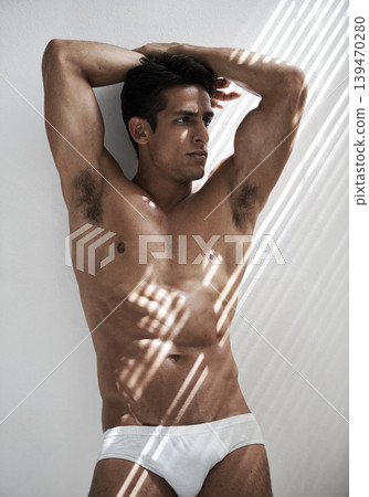Muscular, flexing and man in sexy underwear with sunshine, glow or serious attitude in morning. Thinking, model and shirtless person in white background with strong arms and bodybuilder with health Muscular, flexing and man in sexy underwear with sunshine, glow or serious attitude in morning. Thinking, model and shirtless person in white background with strong arms and bodybuilder with health 139470280