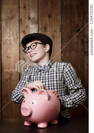 Piggy bank, money and boy child with savings, growth or investment, planning or learning at home. Happy, budget and kid in a house with coin, container or cash box for future, financial and security 139470292