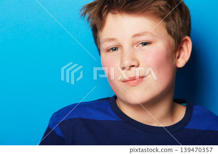 Child, portrait and blue background with stylish fashion, youth and trendy clothes in a studio. Young boy, kid and face with confidence and student with modern and casual style with relax model Child, portrait and blue background with stylish fashion, youth and trendy clothes in a studio. Young boy, kid and face with confidence and student with modern and casual style with relax model 139470357