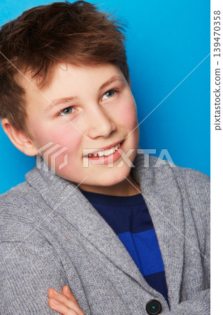 Fashion, thinking and boy child in studio with arms crossed confidence, smile or positive attitude on blue background. Style, face and proud fashionable kid model with cool, outfit or clothing choice Fashion, thinking and boy child in studio with arms crossed confidence, smile or positive attitude on blue background. Style, face and proud fashionable kid model with cool, outfit or clothing choice 139470358