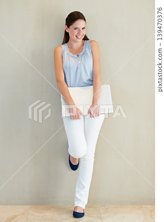 Happy woman, portrait and laptop for business, social media or communication at home. Young female person, brunette or freelancer smile leaning on wall with computer for online networking at house Happy woman, portrait and laptop for business, social media or communication at home. Young female person, brunette or freelancer smile leaning on wall with computer for online networking at house 139470376