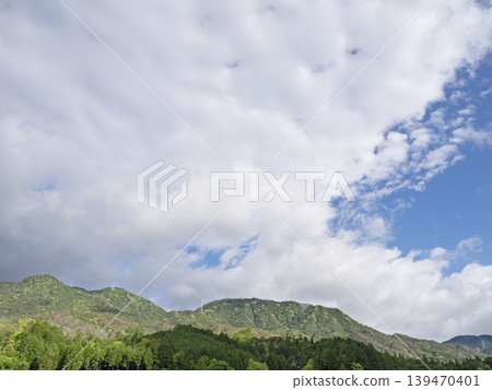 A feeling of liberation that sets the mind free. The lush green mountain peaks and the vast sky above. A feeling of liberation that sets the mind free. The lush green mountain peaks and the vast sky above. 139470401