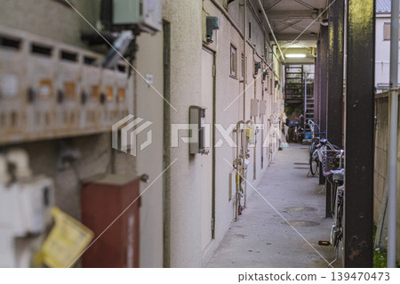 A scene of everyday life: the common corridor of an old apartment building lined with bicycles. 139470473
