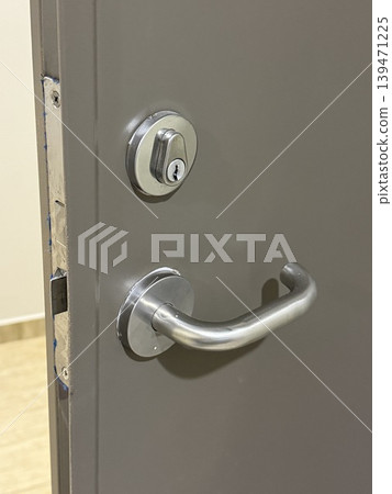 Metal door handle and lock on smooth surface background, close-up showing detail and design Metal door handle and lock on smooth surface background, close-up showing detail and design 139471225