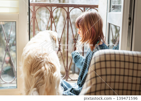 Child and dog bonding by window at home Child and dog bonding by window at home 139471596
