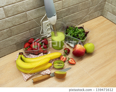 Preparing a healthy green smoothie with fresh fruits 139471612