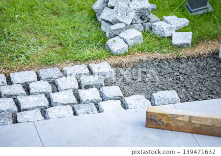 Cobblestone pavement installation with tools and groundwork preparation 139471632