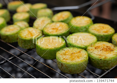 Chopped zucchini and khachapuri roasting on fire seasoned with aroma herbs and spices. Delicious fresh vegetables vegetarian grilling on barbecue smoker grid. Diet vegan bbq. Outdoor recreation Chopped zucchini and khachapuri roasting on fire seasoned with aroma herbs and spices. Delicious fresh vegetables vegetarian grilling on barbecue smoker grid. Diet vegan bbq. Outdoor recreation 139471744