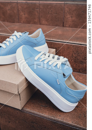 Elegant blue leather womens shoes blank product for branding displayed on recycled cardboard box. New casual female sneakers no-brand footwear e-commerce. No logo product unbranded fashion Elegant blue leather womens shoes blank product for branding displayed on recycled cardboard box. New casual female sneakers no-brand footwear e-commerce. No logo product unbranded fashion 139471746