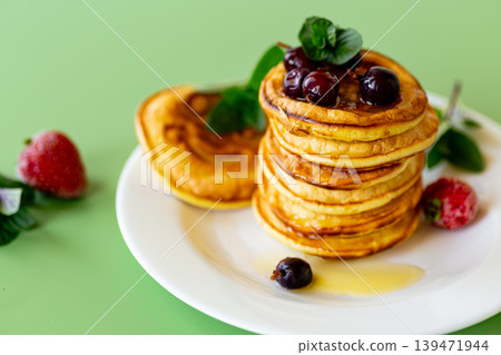 Sweet breakfast pancakes served with fresh berries and honey Sweet breakfast pancakes served with fresh berries and honey 139471944