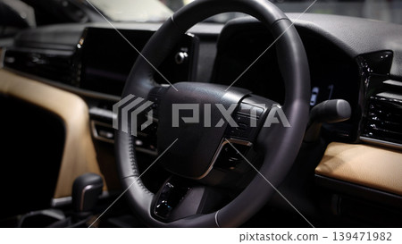 EV Car steering wheel. Modern car interior with luxury steering wheel dashboard and digital monitor controls. Steering wheel and automotive cabin. Car technology comfort and premium design in EV car. EV Car steering wheel. Modern car interior with luxury steering wheel dashboard and digital monitor controls. Steering wheel and automotive cabin. Car technology comfort and premium design in EV car. 139471982