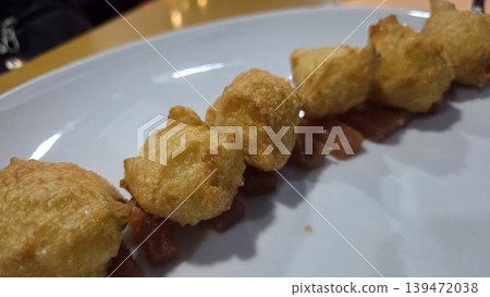 Crispy battered bite skewers served on white plate with sauce for spanish tapas appetizer background and menu layout Crispy battered bite skewers served on white plate with sauce for spanish tapas appetizer background and menu layout 139472038