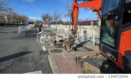 Road repair construction with excavator breaking up asphalt on a city street for infrastructure background and maintenance banner Road repair construction with excavator breaking up asphalt on a city street for infrastructure background and maintenance banner 139472044