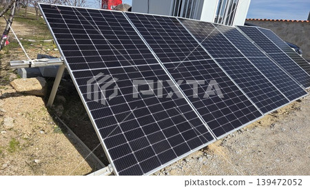 Ground mounted solar panel array near building for renewable energy background and sustainable power banner design Ground mounted solar panel array near building for renewable energy background and sustainable power banner design 139472052