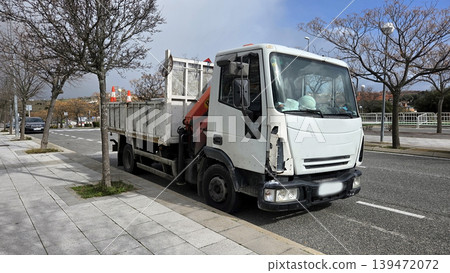 White iveco work truck parked at urban road repair site for pipeline transport and construction background White iveco work truck parked at urban road repair site for pipeline transport and construction background 139472072