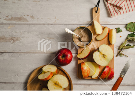Red apples, whole and sliced on a wooden cutting board, lifestyle, top view. Autumn abstract food background. Red apples, whole and sliced on a wooden cutting board, lifestyle, top view. Autumn abstract food background. 139472104