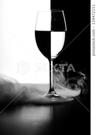 a glass of water and smoke on a black and white background a glass of water and smoke on a black and white background 139472151