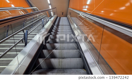 Madrid metro close up view from escalator base with orange tiled walls for background and transportation banner design Madrid metro close up view from escalator base with orange tiled walls for background and transportation banner design 139472242