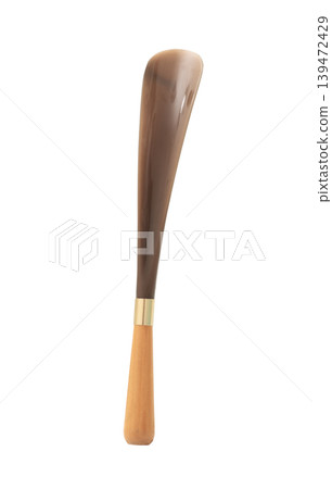 Shoe horn made of natural horn with a wooden handle and brass ring, isolated on white background. Shoe horn made of natural horn with a wooden handle and brass ring, isolated on white background. 139472429