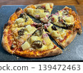 Homemade pizza with pineapple ham and mushrooms on a rustic board. Warm baked cheese creates an inviting comfort food mood 139472463