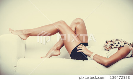 Girl relaxing on sofa, beauty female legs Girl relaxing on sofa, beauty female legs 139472528