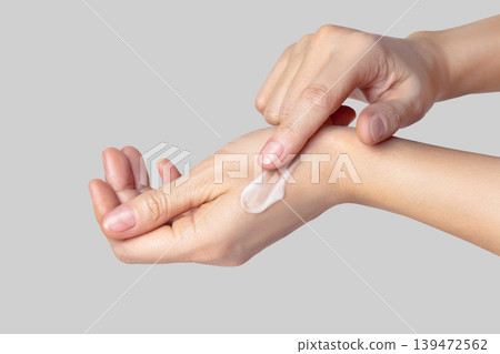 Hands with a white swatch, smear of cream. skin care, hand care, facial care. on gray background close up Hands with a white swatch, smear of cream. skin care, hand care, facial care. on gray background close up 139472562