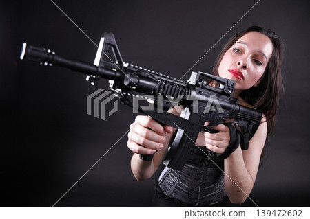 Girl holding Rifle on black background 139472602