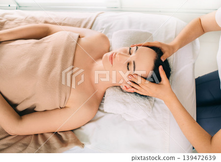 Brunette Woman relaxing during spa treatment . She receive relaxation massage while spa weekend Brunette Woman relaxing during spa treatment . She receive relaxation massage while spa weekend 139472639
