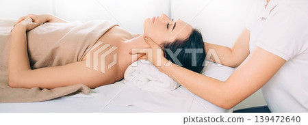 Brunette Woman relaxing during spa treatment . She receive relaxation massage while spa weekend 139472640