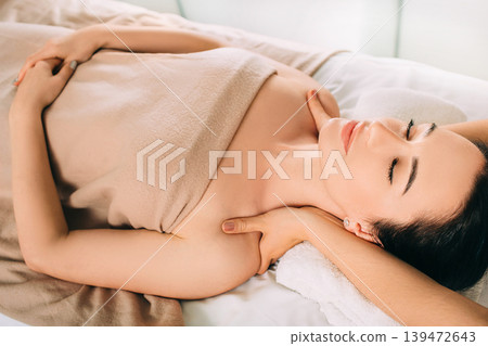 Brunette Woman relaxing during spa treatment . She receive relaxation massage while spa weekend Brunette Woman relaxing during spa treatment . She receive relaxation massage while spa weekend 139472643