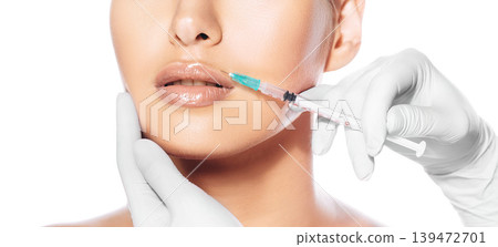 Cropped female face during lips augmentation procedure. Injections for increase lips shape 139472701