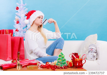 Woman in Santa hat holding credit card Woman in Santa hat holding credit card 139472737