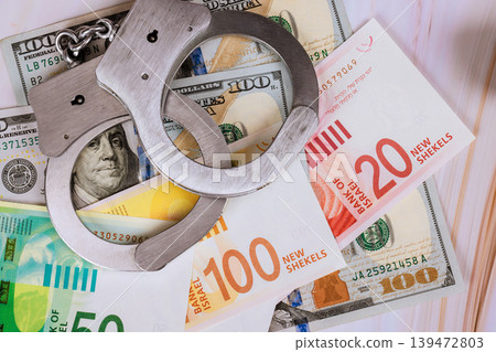Handcuffs on US dollars Israeli new shekels at law event. Handcuffs on US dollars Israeli new shekels at law event. 139472803