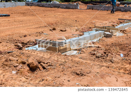 Workers are placing concrete blocks to build foundation at construction site Workers are placing concrete blocks to build foundation at construction site 139472845