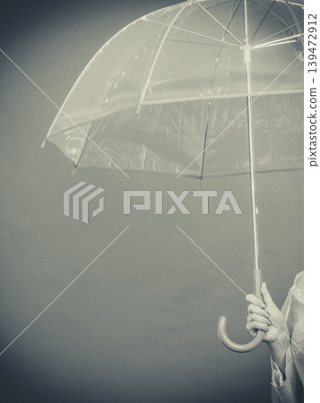 Woman wearing raincoat holding umbrella 139472912
