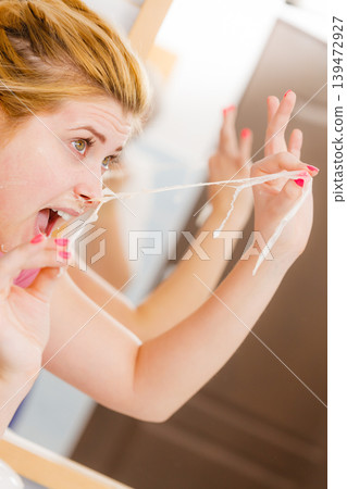 Woman peeling off gel mask from face Woman peeling off gel mask from face 139472927