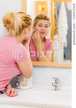 woman removing peel off mask from her face woman removing peel off mask from her face 139472928