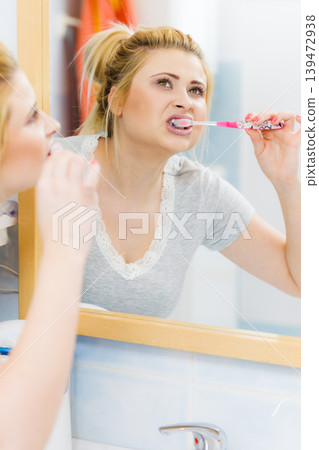 Woman brushing cleaning teeth in bathroom Woman brushing cleaning teeth in bathroom 139472938