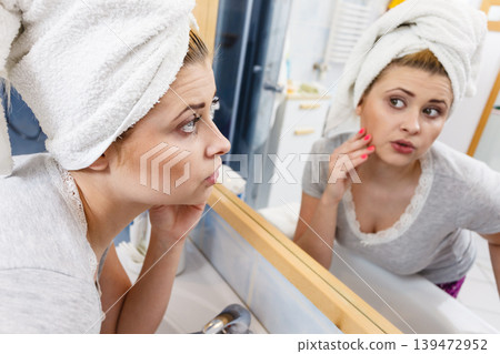 Woman looking at her reflection in mirror Woman looking at her reflection in mirror 139472952