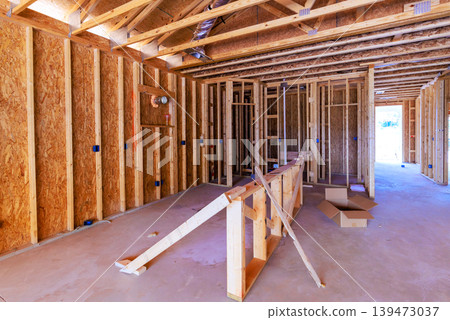 Workers are installing wooden frames in house under construction in residential neighborhood Workers are installing wooden frames in house under construction in residential neighborhood 139473037