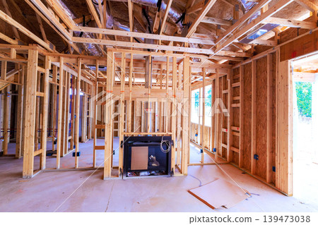 Workers are building new house with wooden framing an area set for fireplace floor is clear empty. Workers are building new house with wooden framing an area set for fireplace floor is clear empty. 139473038